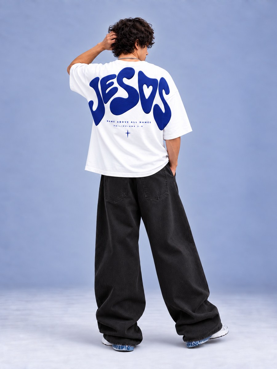 White oversized tee with 'JESUS' in blue bubble letters and 'Name above all names, Philippians 2:9' on the back