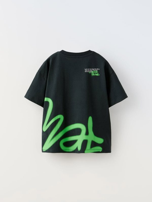 Black tee laid flat with an oversized neon green script print at the hem