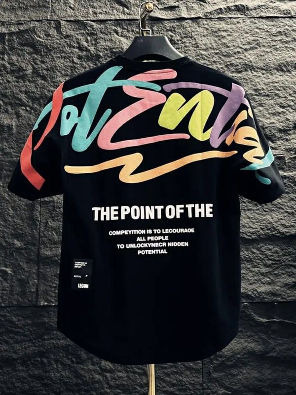 Black tee hung against stone with a multicolour 'Potential' brush script print